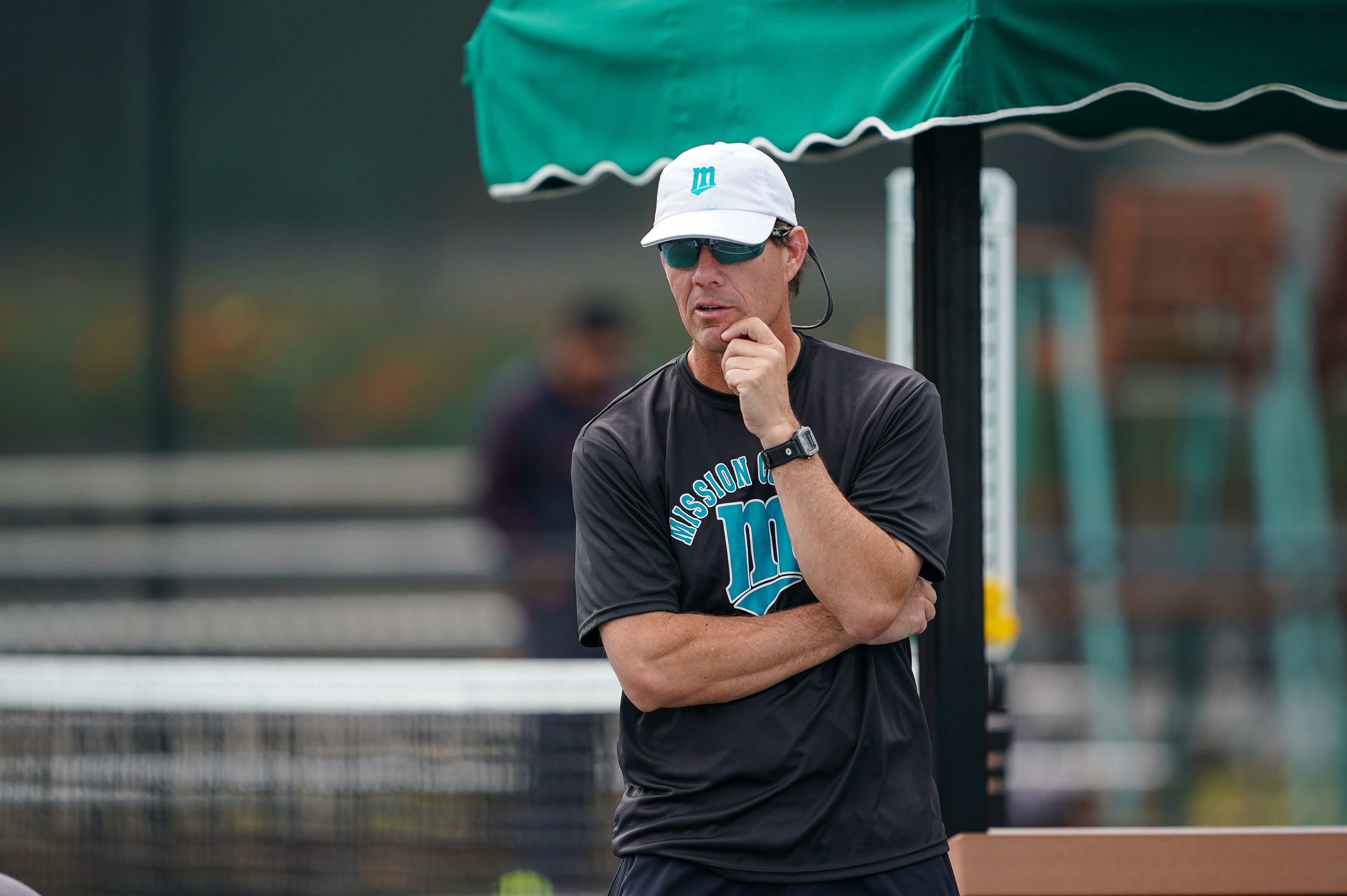 Scott Howard watching play on court with one hand resting on his chin